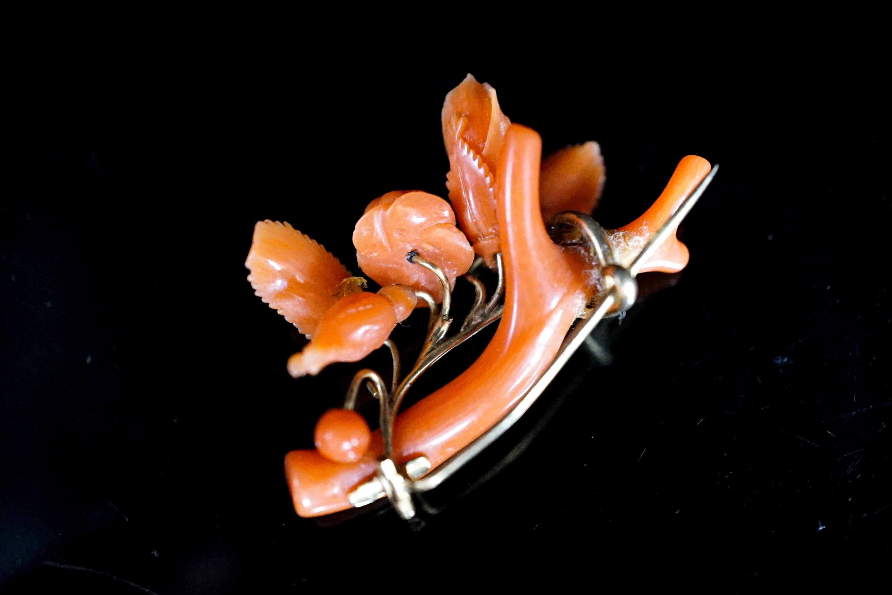 A Victorian carved coral and yellow metal mounted brooch, 40mm, gross 5.9 grams.